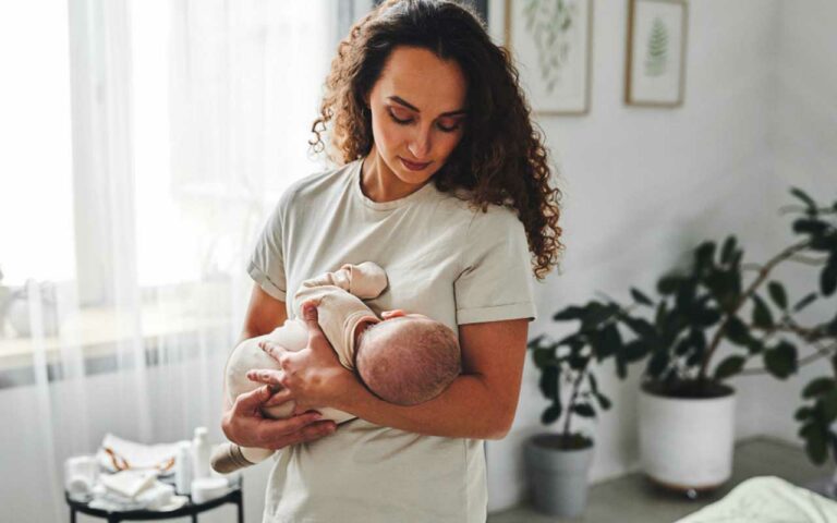 A newborn care specialist holds a baby after changing